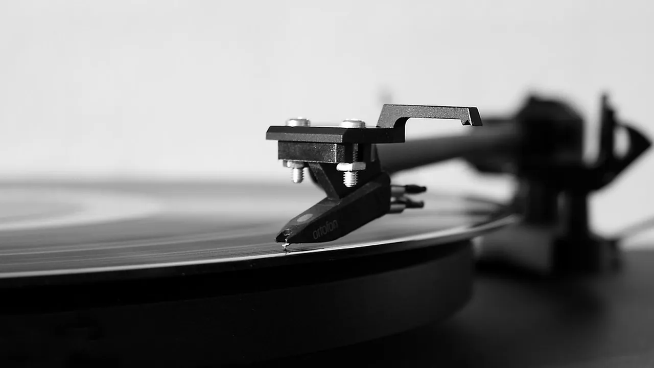 Bras de lecture et pointe posés sur le sillon d'un disque